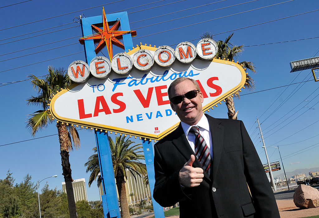 man standing in front of las vegas sign with thumbs up