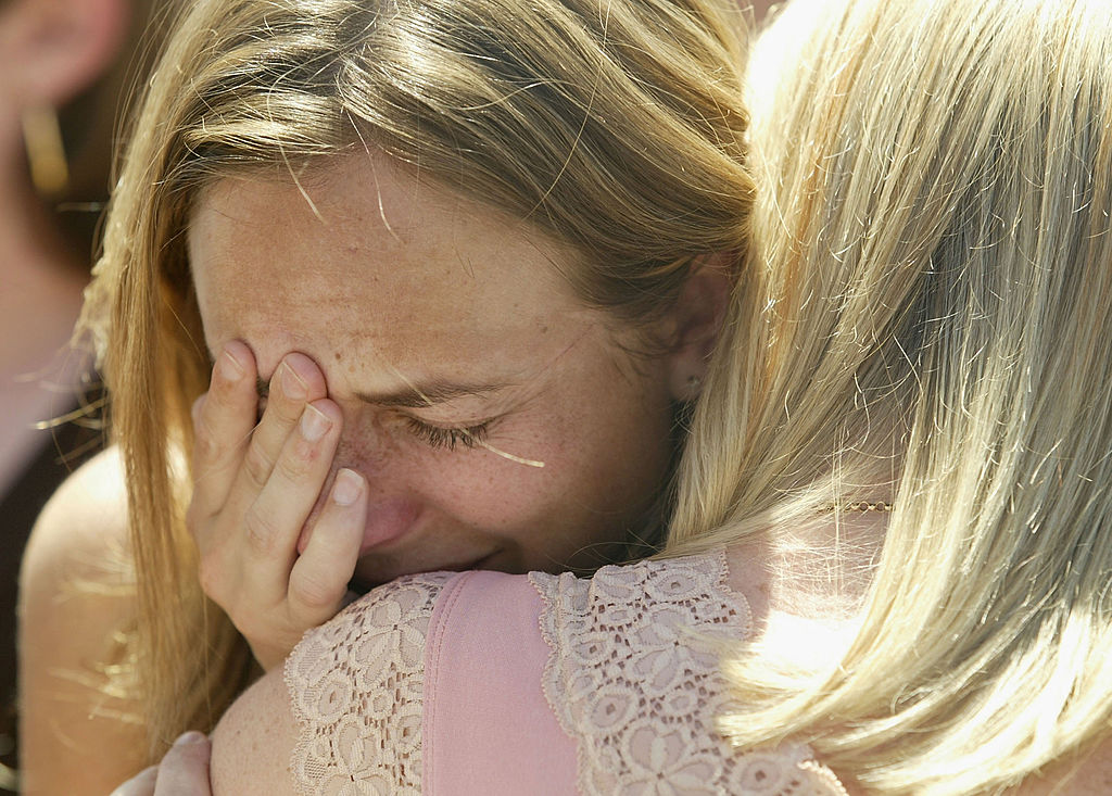 woman crying on another woman's shoulder