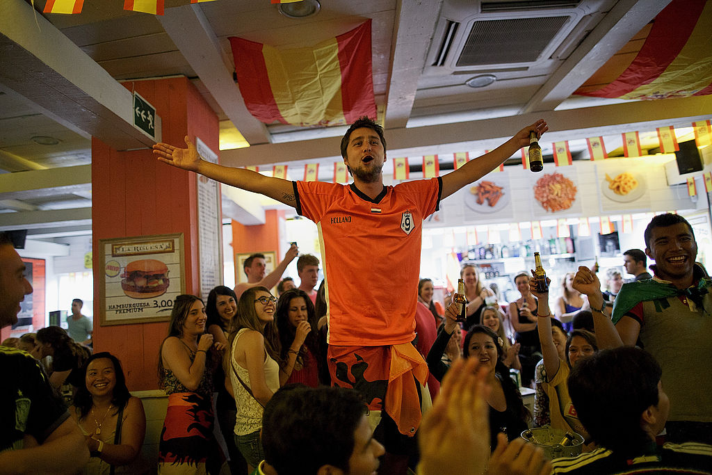 fans watching soccer game in bar