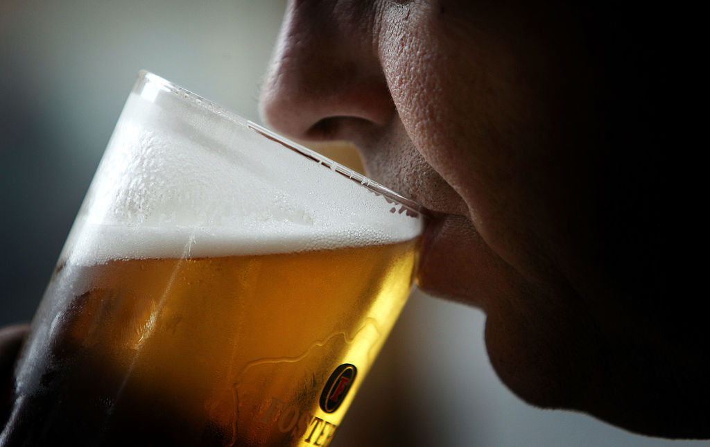 man drinking a glass of beer