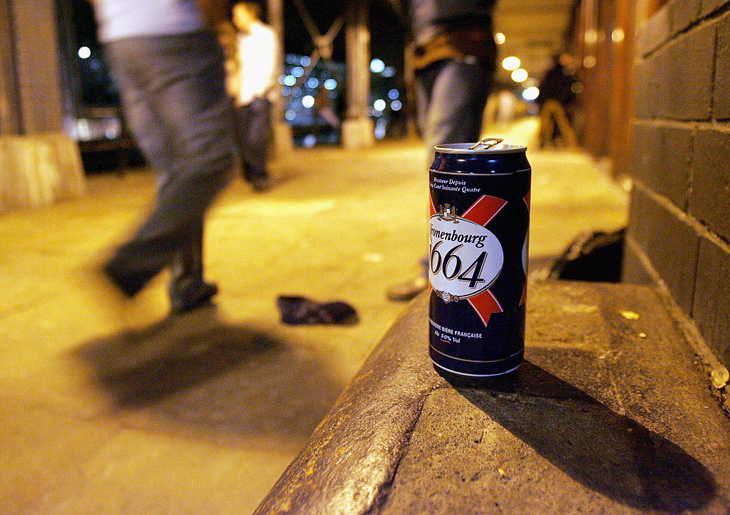 Can of beer sitting on a sidewalk