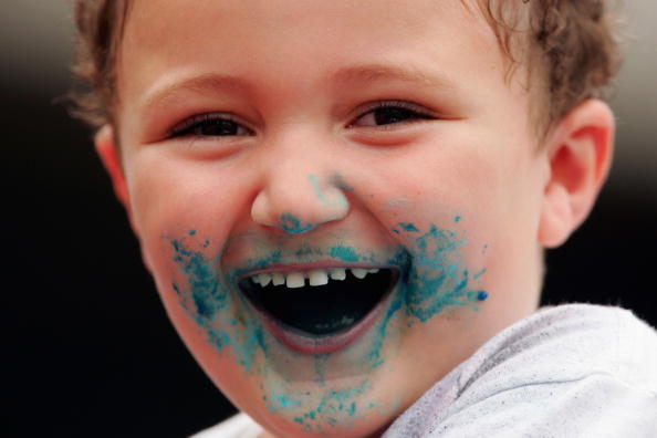 Kleiner Junge mit blauen Süßigkeiten im Gesicht