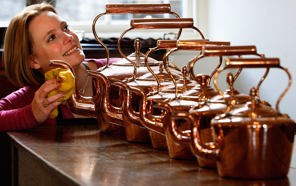 woman shining copper kettle