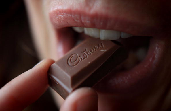 woman eating a piece of chocolate