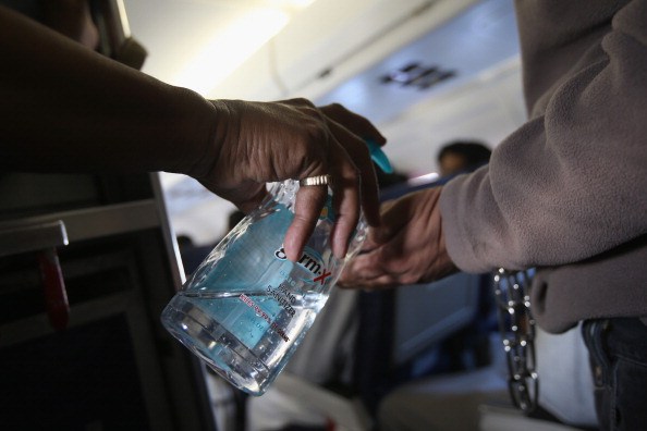 People using hand sanitizer on plane