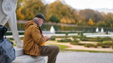 a man sitting on a bench looking at his phone