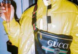 man in yellow jacket holding black leather bag