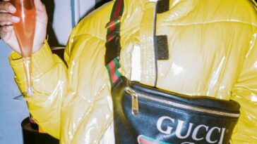 man in yellow jacket holding black leather bag