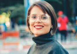 Photo of a Woman Wearing Eyeglasses Holding on Black Steel Handrail