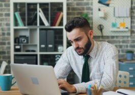 a man sitting in front of a laptop computer
